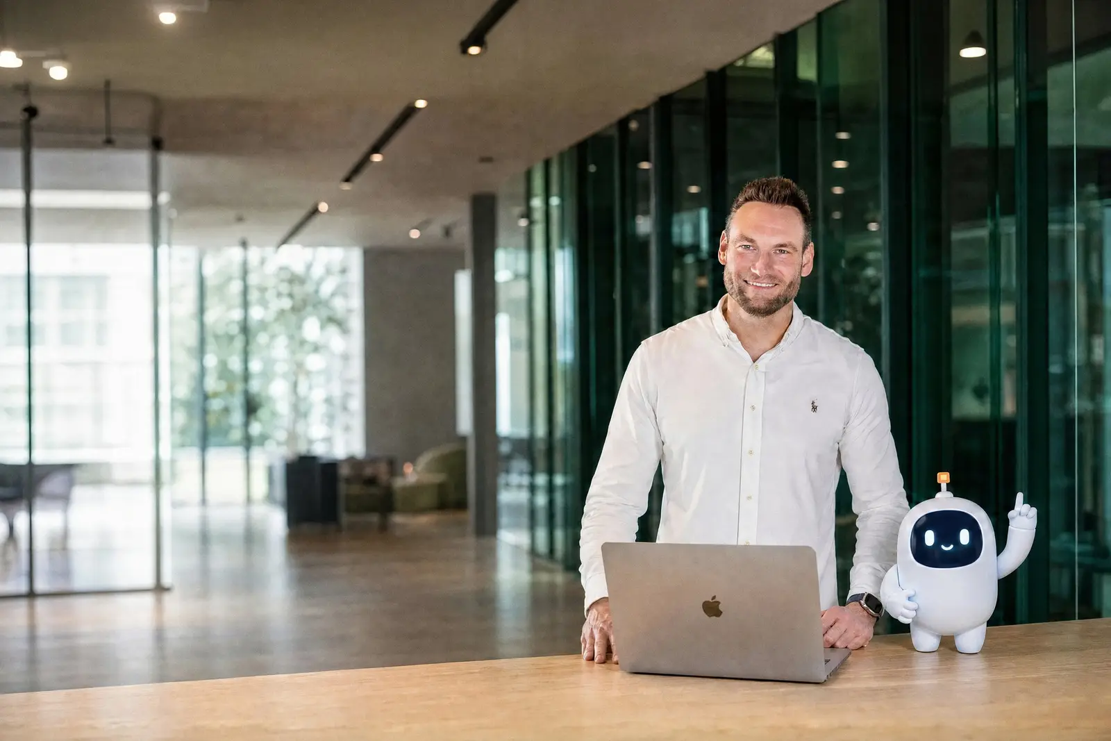 Oliver Leifken am Laptop, daneben Ranky, das Maskottchen von RankMeister